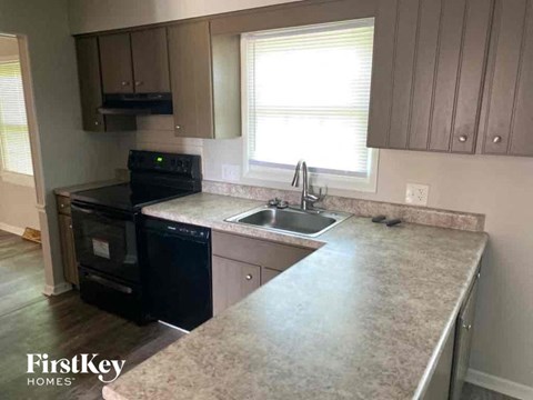 A kitchen with a black oven and a granite countertop.