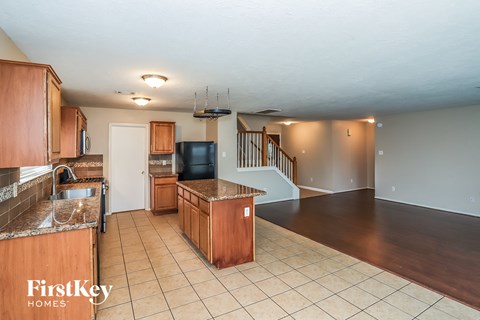 A kitchen with wooden cabinets and a black refrigerator.