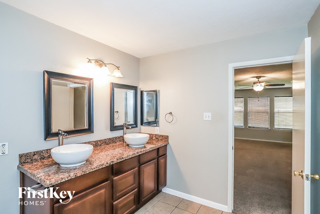 A bathroom with a brown countertop and two sinks.
