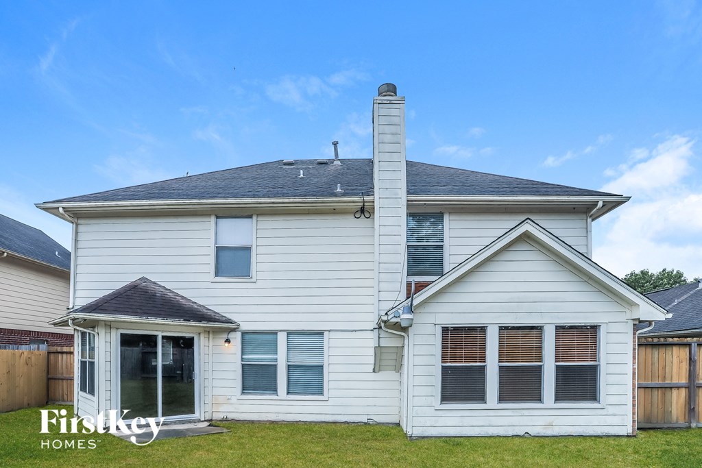 A two-story house with a white exterior and a black roof.