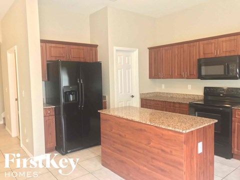a kitchen with wooden cabinets and a black refrigerator