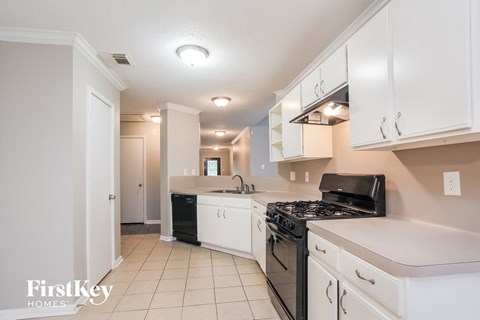 A kitchen with white cabinets and a black stove top.