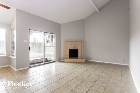 A spacious living room with a fireplace and sliding glass doors.