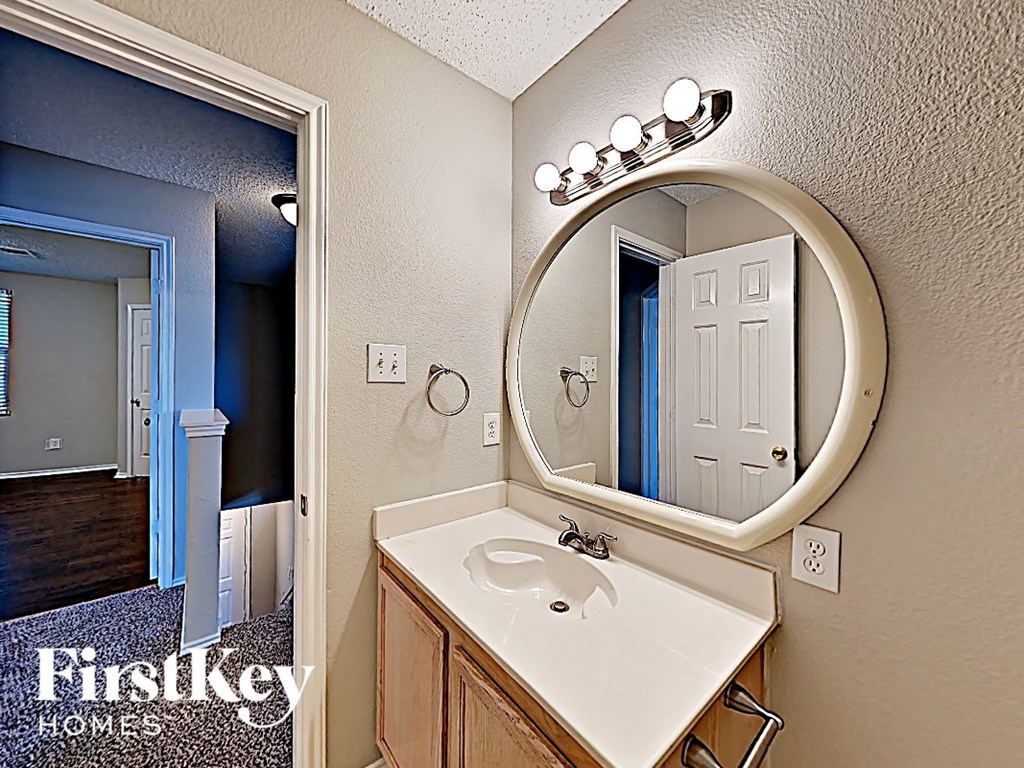 a bathroom with a sink and a mirror and a door