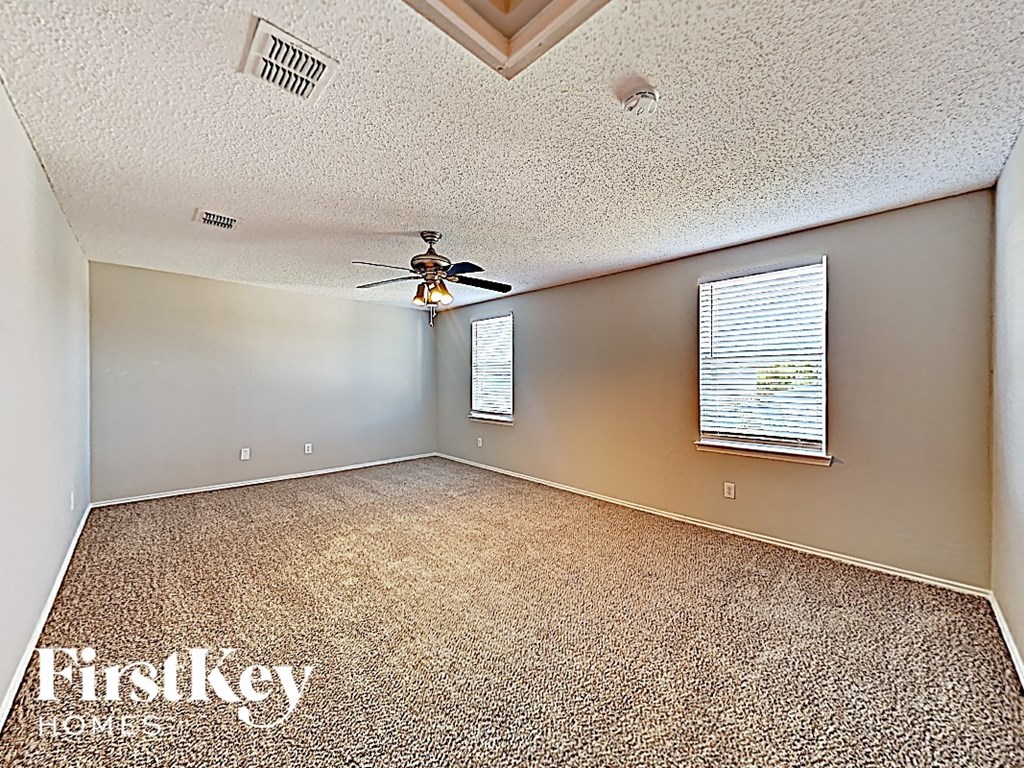 an empty room with a ceiling fan and a window
