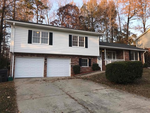 a white and brick house with two garage doors