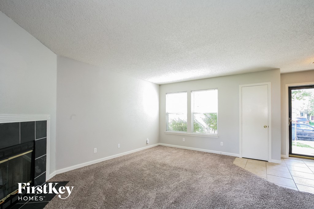 a living room with a fireplace and a carpeted floor