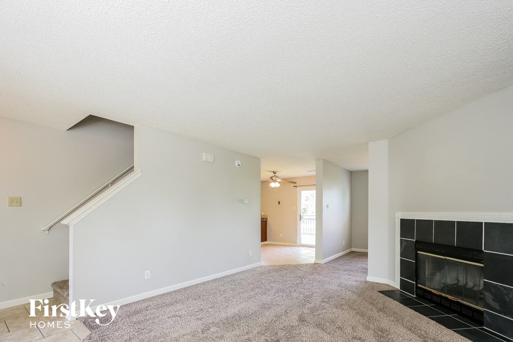 a living room with a fireplace and a carpeted floor