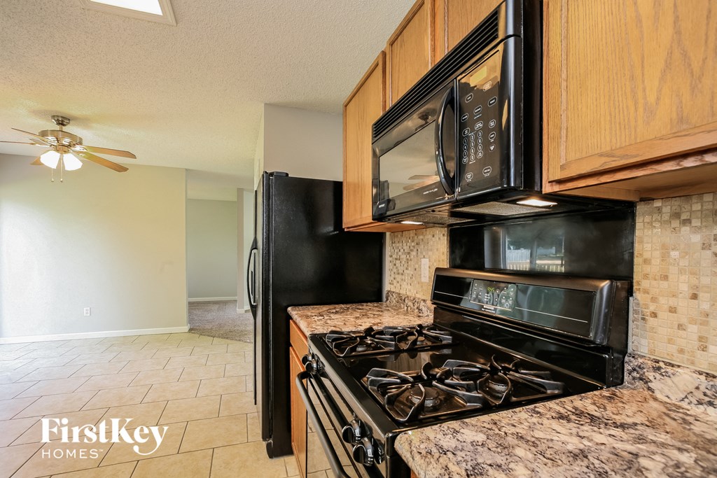 a kitchen with a stove and a microwave and a refrigerator