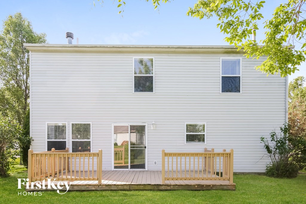 a white house with a porch and two wooden benches