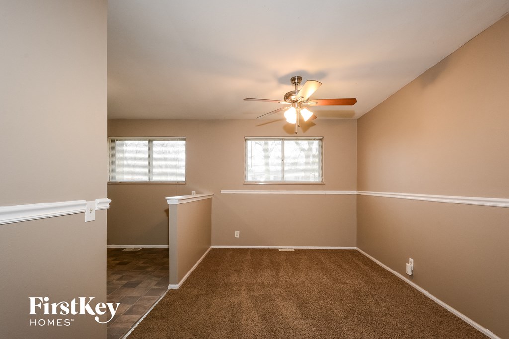 an empty room with a ceiling fan and a window