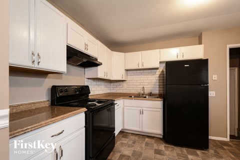 a kitchen with black appliances and white cabinets