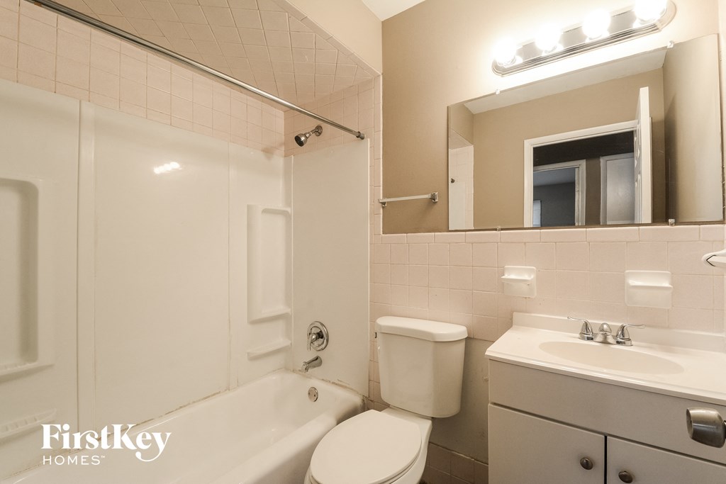 a bathroom with a toilet sink and tub and a mirror