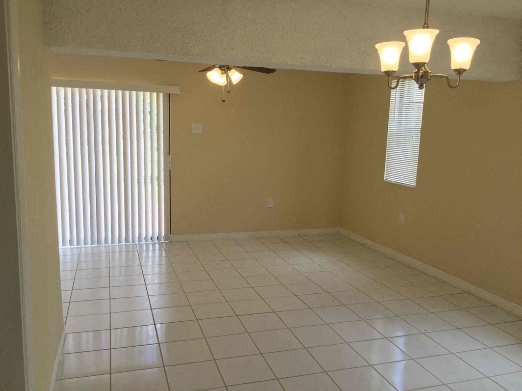 an empty living room with a tiled floor