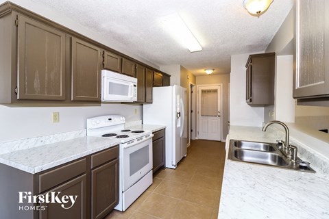 A kitchen with brown cabinets and a white stove top oven.