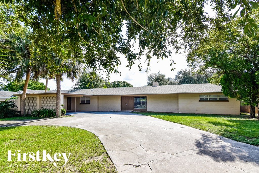 a white house with a driveway and trees