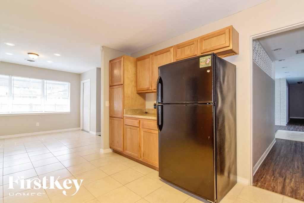 a kitchen with a stainless steel refrigerator and wooden cabinets