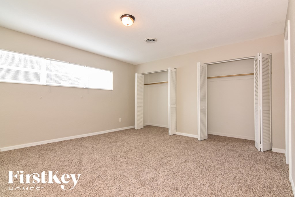a bedroom with two closets and a carpeted floor