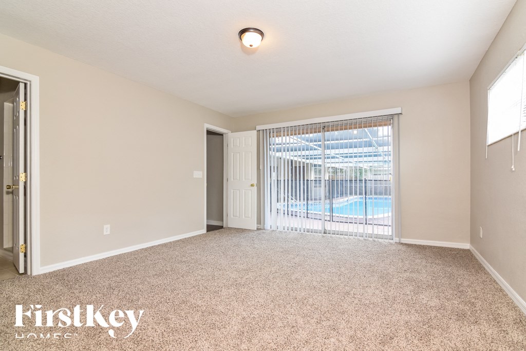 the living room is spacious and has a sliding glass door to the pool