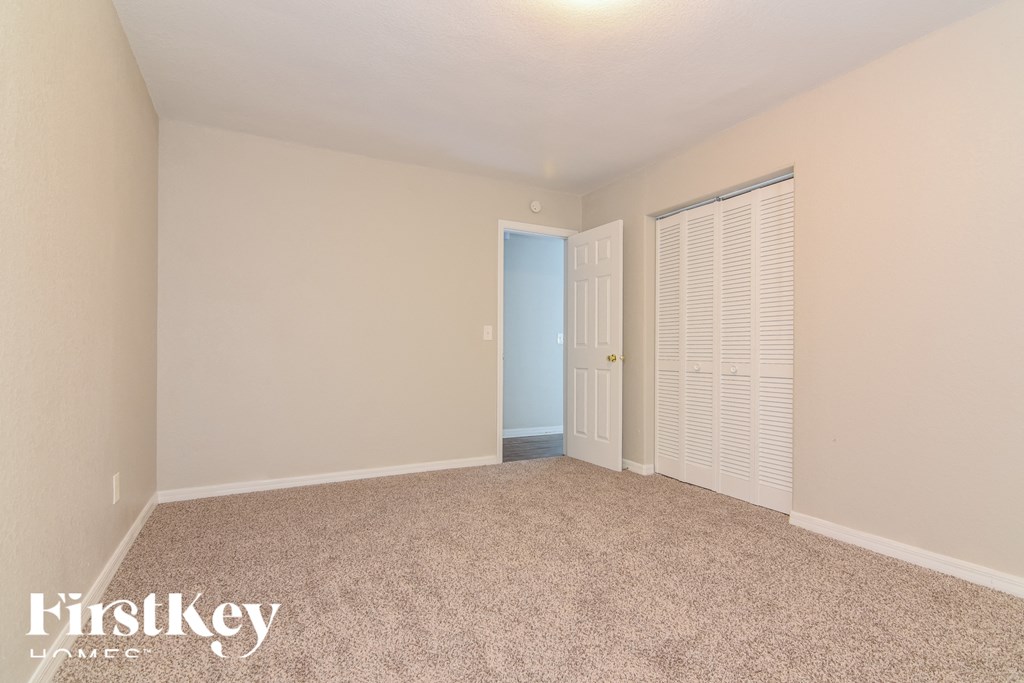 a spacious living room with carpet and a door to a closet
