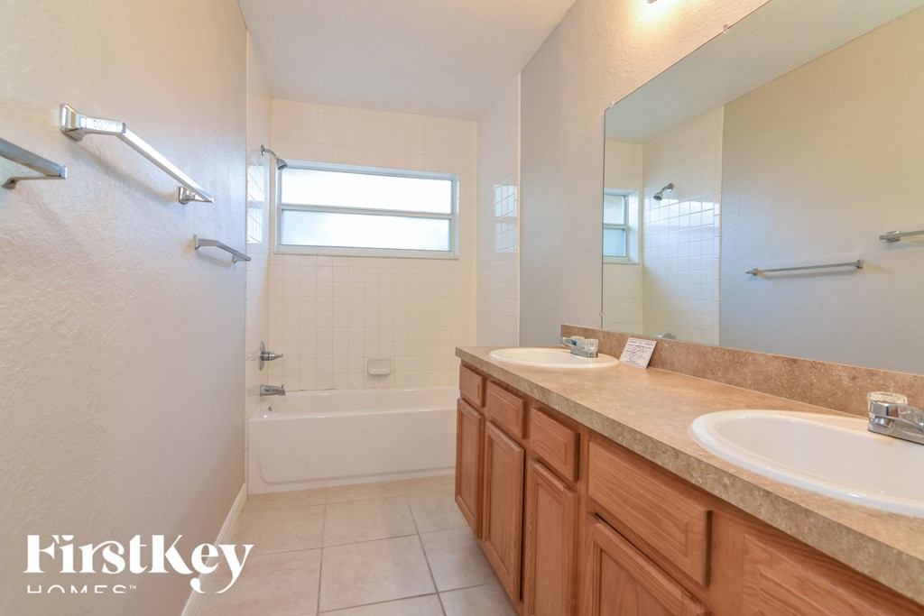a bathroom with two sinks and a shower and a mirror