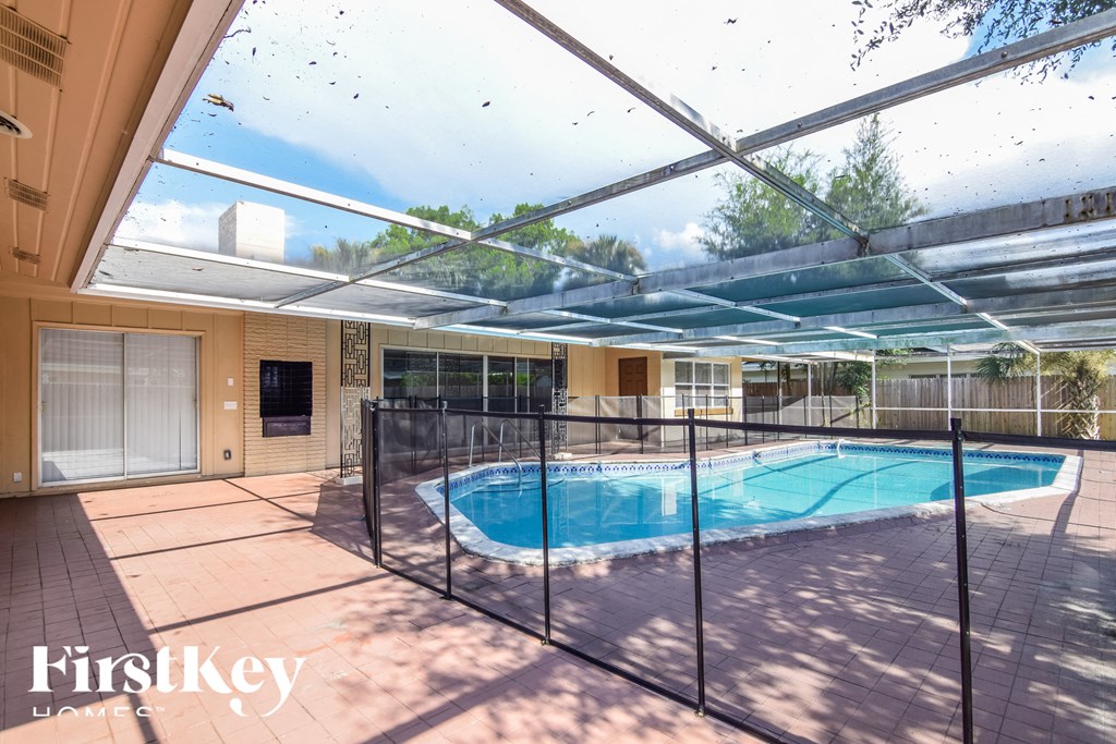 a swimming pool in a house with a patio and a pool enclosure