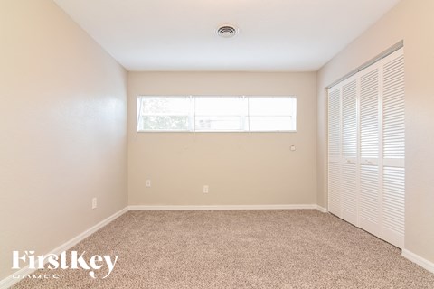 a spacious room with carpet and a large window