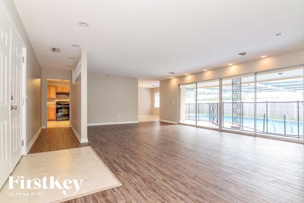 an empty living room with a view of a swimming pool