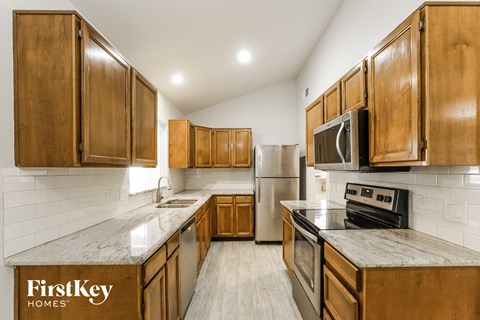 a kitchen with wooden cabinets and stainless steel appliances