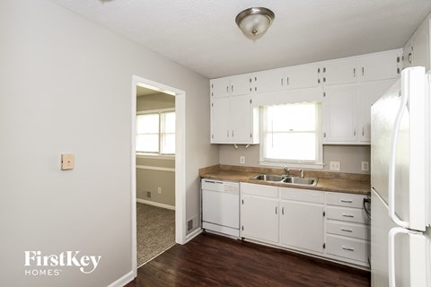 a kitchen with white cabinets and a sink and a refrigerator