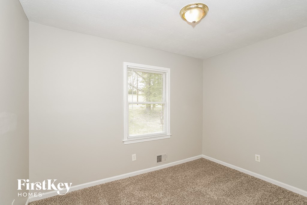 a bedroom with a carpeted floor and a window