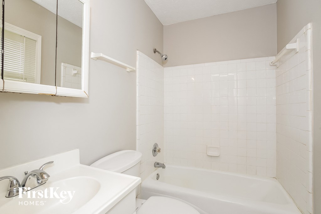 a white bathroom with a sink toilet and bath tub