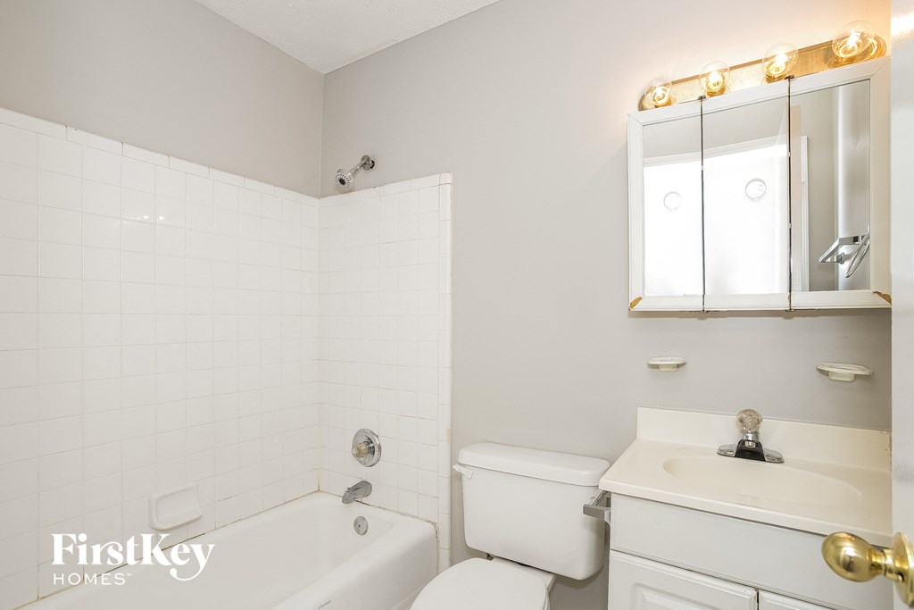 a white bathroom with a tub and a sink and a toilet