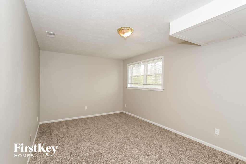 an empty room with carpet and a window