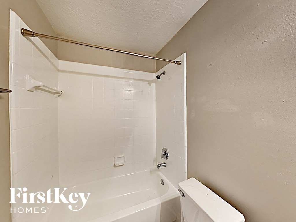 a white bathroom with a tub and a toilet