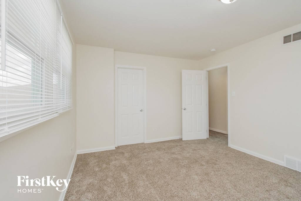 A room with two doors and a carpeted floor.