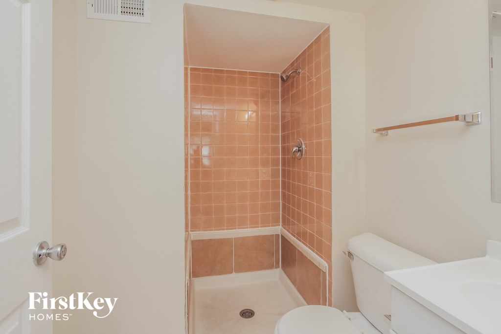 A bathroom with a tiled shower and a toilet.