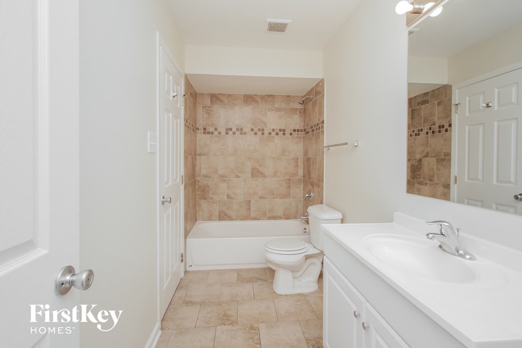 A bathroom with a toilet, sink, and shower.