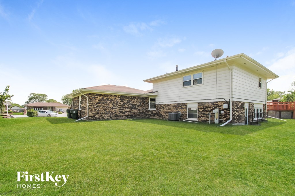 A house with a stone wall and a satellite dish on the roof.