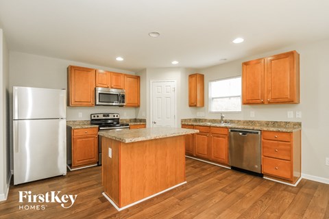 A kitchen with wooden cabinets and a stainless steel refrigerator.