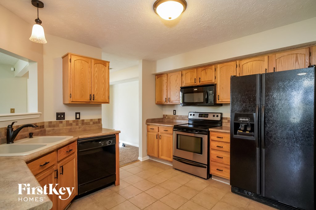 a kitchen with black appliances and wooden cabinets