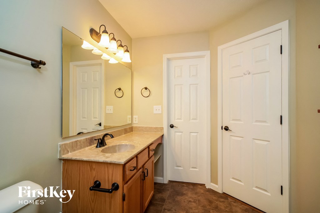 a bathroom with a sink and a mirror and two doors