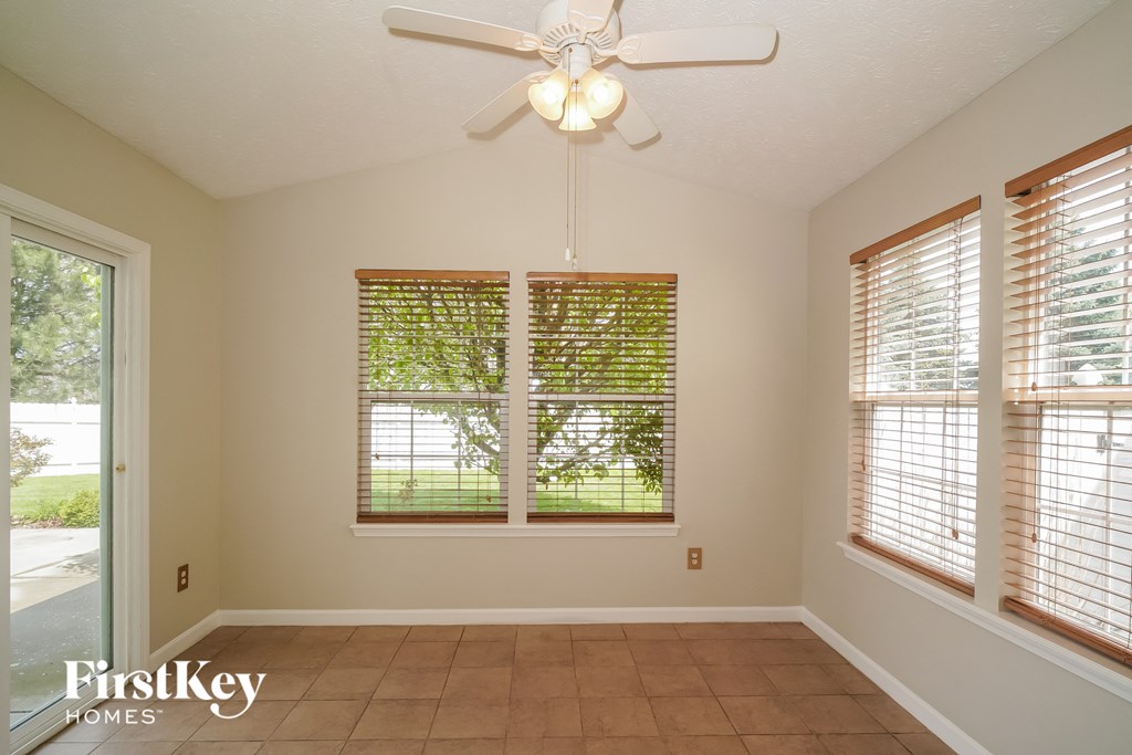 a dining room with a ceiling fan and a window