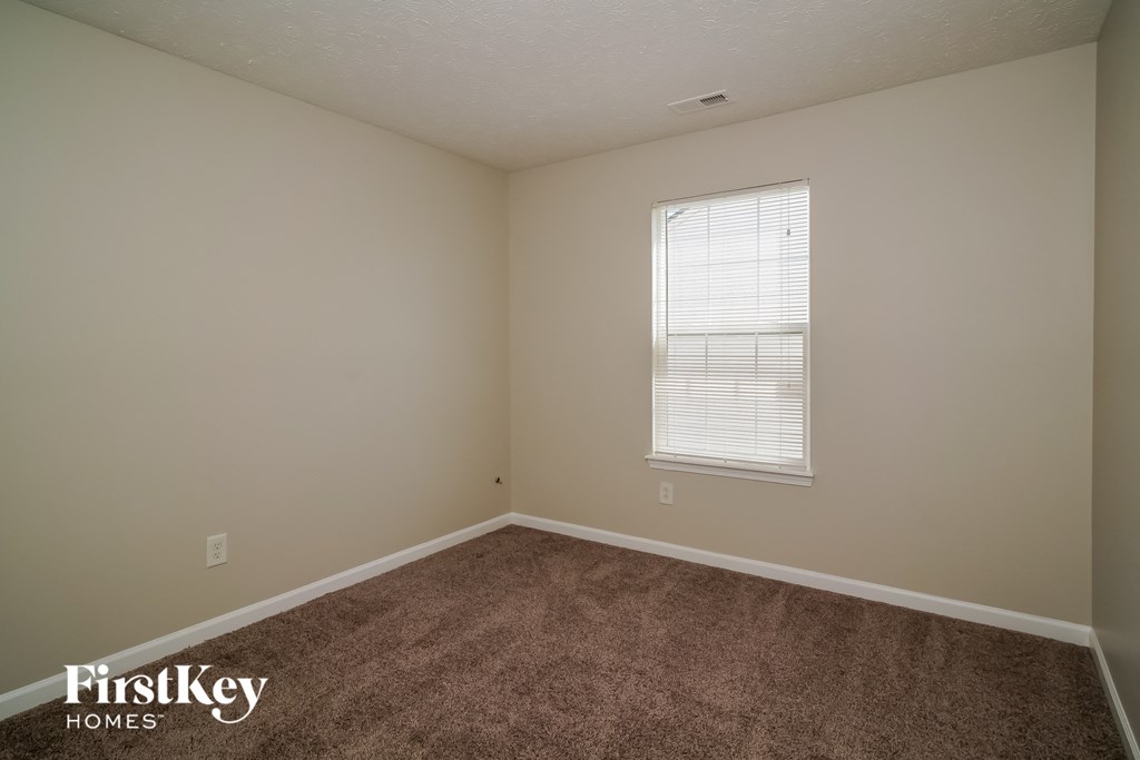a bedroom with a carpeted floor and a window