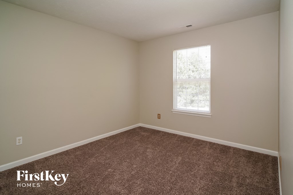 a bedroom with a carpeted floor and a window