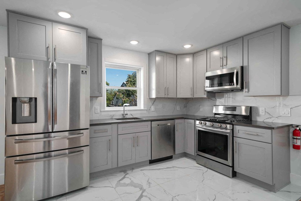 a kitchen with stainless steel appliances and white cabinets