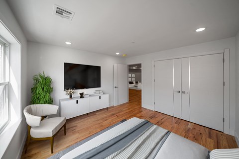 a white living room with a bed and a television