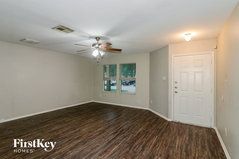 A room with wooden floors and a ceiling fan.