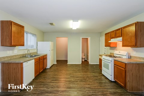 A kitchen with wooden cabinets and a white fridge.