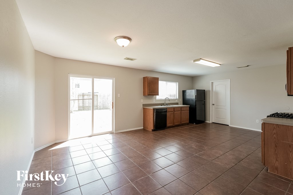 an empty kitchen with a sliding glass door to the patio
